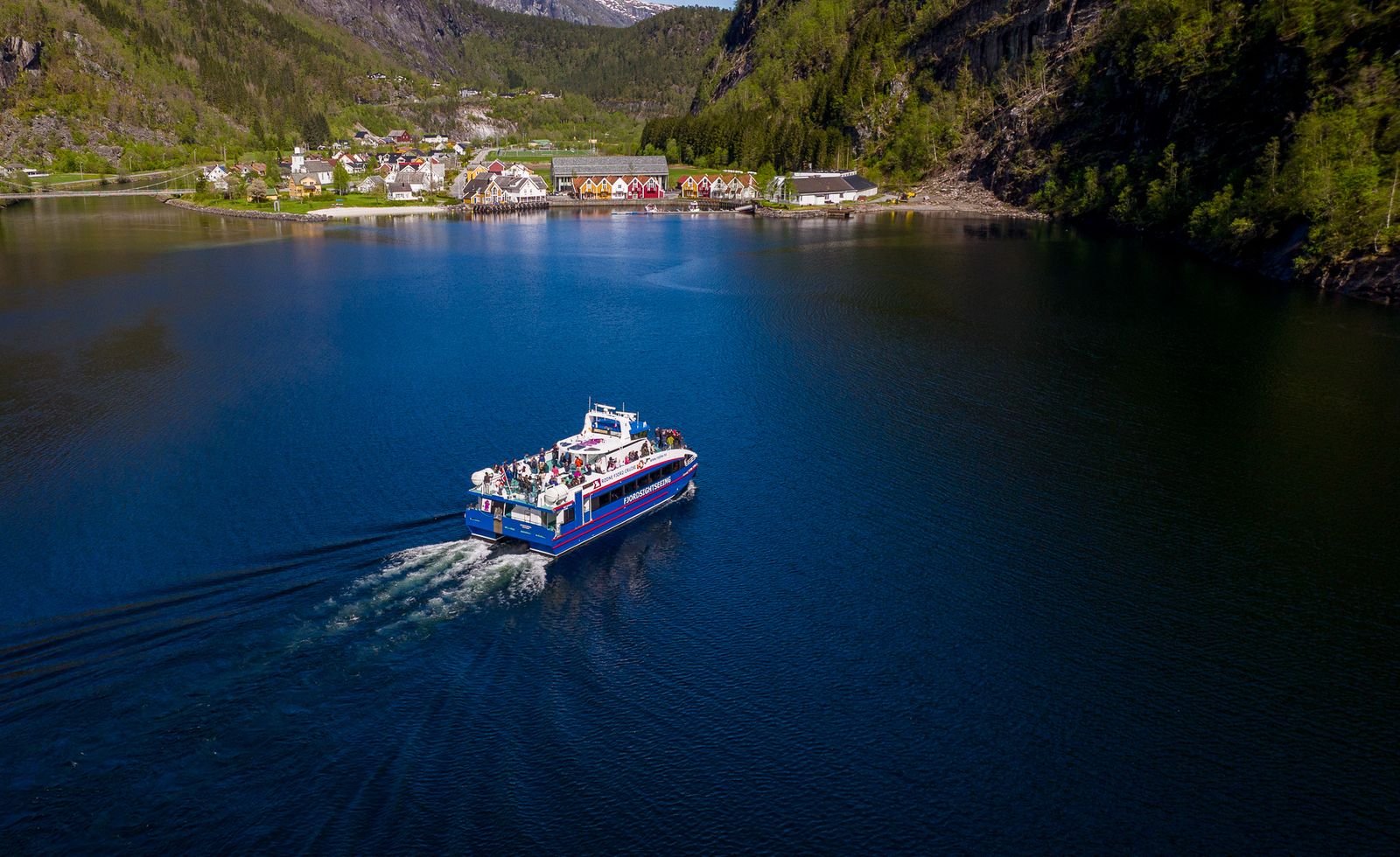 Et fjordsightseeing-fartøy i full fart på Mofjorden, der Kystverket nå foreslår fartsgrense på 5 knop etter eksplosiv vekst i næringsaktivitet.